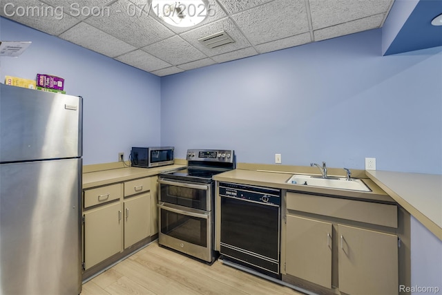 15801 Providence Dr # 5, Southfield, MI 48075 - kitchen with stainless steel appliances, light wood finished floors, a paneled ceiling, and light countertops