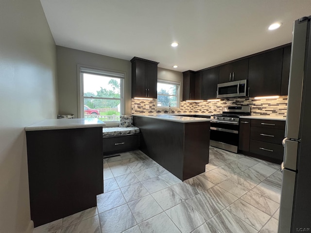2244 Shannon Dr, Adrian, MI 49221 - kitchen featuring stainless steel appliances, light countertops, light marble finish floors, decorative backsplash, and recessed lighting