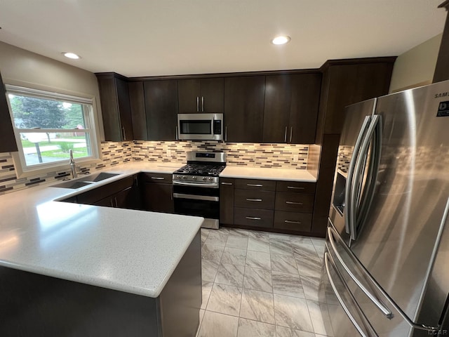 2244 Shannon Dr, Adrian, MI 49221 - kitchen featuring appliances with stainless steel finishes, light marble finish flooring, tasteful backsplash, dark brown cabinets, and recessed lighting