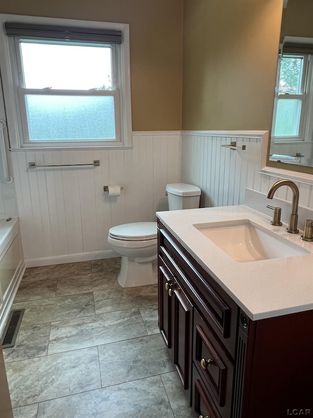 2244 Shannon Dr, Adrian, MI 49221 - bathroom with vanity, wainscoting, and healthy amount of natural light