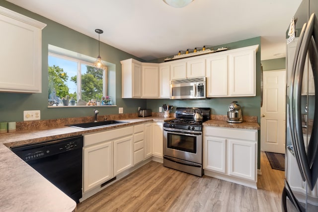 127 Ridgeview Ct, Grass Lake, MI 49240 - kitchen featuring stainless steel appliances, light wood-style floors, white cabinetry, and decorative light fixtures
