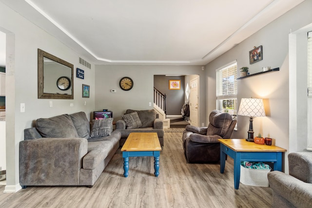 127 Ridgeview Ct, Grass Lake, MI 49240 - living area featuring stairs, wood finished floors, and a tray ceiling