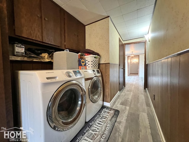 4949 S Iva Rd, Merrill, MI 48637 - washroom with cabinet space, wainscoting, washing machine and clothes dryer, light wood-style flooring, and wooden walls