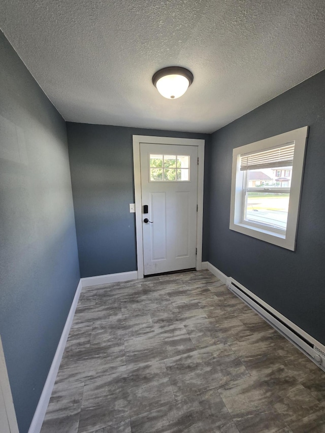 7 Hewitt St, Quincy, MI 49082 - doorway featuring a textured ceiling and a baseboard heating unit