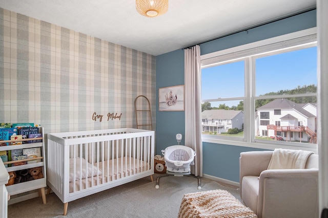 5665 Koster Dr SW, Wyoming, MI 49418 - carpeted bedroom with a nursery area, wallpapered walls, and a residential view