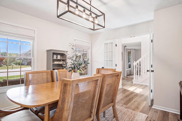 5665 Koster Dr SW, Wyoming, MI 49418 - dining space featuring wood finished floors, stairway, and a chandelier