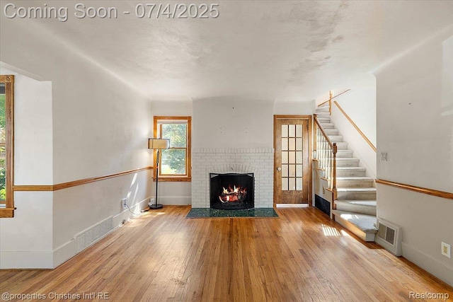 524 Oakland Ave, Birmingham, MI 48009 - unfurnished living room featuring hardwood / wood-style flooring, a fireplace, and stairway