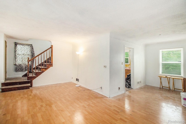 1612 Euclid Ave, Flint, MI 48503 - spare room featuring light wood finished floors, stairs, and a textured ceiling