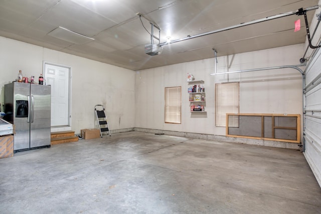 19085 Joslin Cir, Big Rapids, MI 49307 - garage featuring stainless steel refrigerator with ice dispenser and a garage door opener