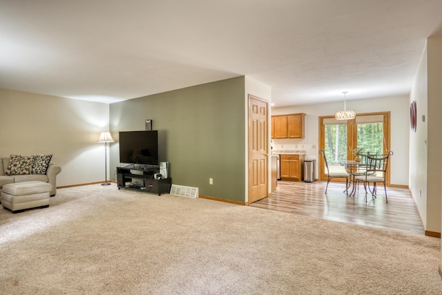 19085 Joslin Cir, Big Rapids, MI 49307 - living room featuring light colored carpet and a chandelier