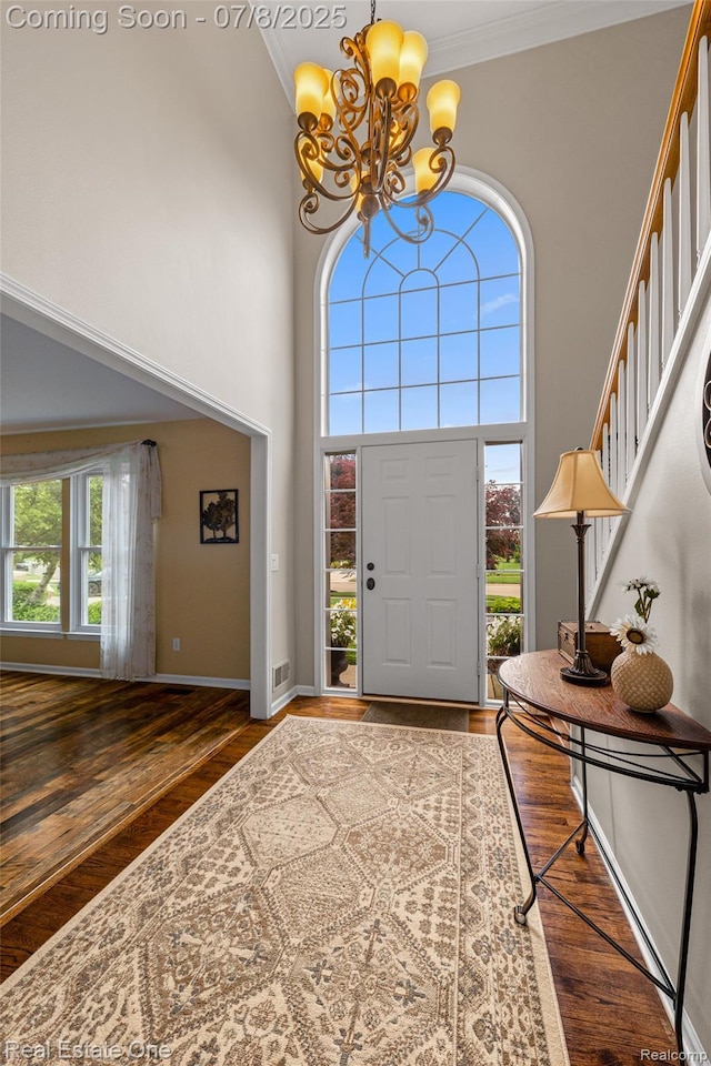 17734 Huron Dr, Macomb, MI 48042 - entryway featuring a chandelier, wood finished floors, a towering ceiling, ornamental molding, and stairway