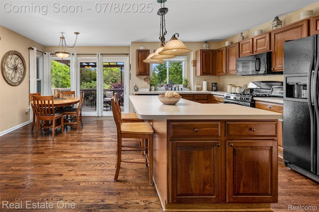 17734 Huron Dr, Macomb, MI 48042 - kitchen featuring black appliances, light countertops, dark wood-style floors, and decorative light fixtures