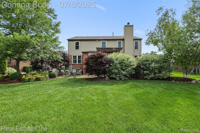 17734 Huron Dr, Macomb, MI 48042 - rear view of house featuring a patio, a chimney, brick siding, and a lawn