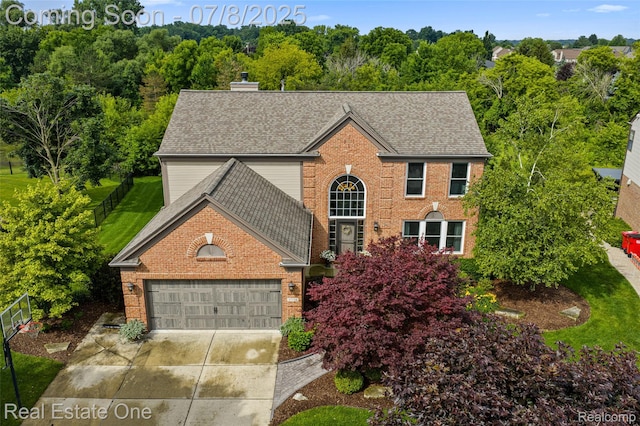 17734 Huron Dr, Macomb, MI 48042 - view of front of house with brick siding, an attached garage, driveway, and a shingled roof