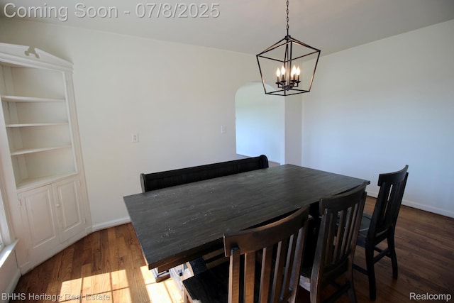 4201 N Burkhart Rd, Howell, MI 48855 - dining space with wood finished floors, arched walkways, and a chandelier