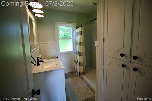 4201 N Burkhart Rd, Howell, MI 48855 - full bathroom with vanity, a shower with shower curtain, a decorative wall, and wainscoting