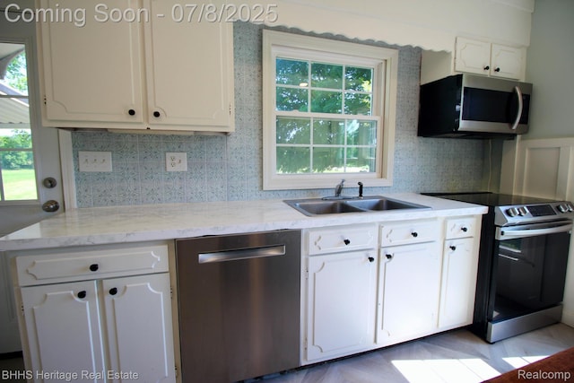 4201 N Burkhart Rd, Howell, MI 48855 - kitchen featuring stainless steel appliances, white cabinets, backsplash, and light stone counters