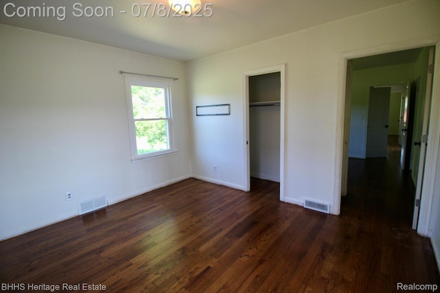 4201 N Burkhart Rd, Howell, MI 48855 - unfurnished bedroom with dark wood-style flooring and a closet