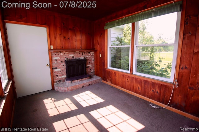 4201 N Burkhart Rd, Howell, MI 48855 - unfurnished living room featuring wooden walls, carpet floors, and a fireplace