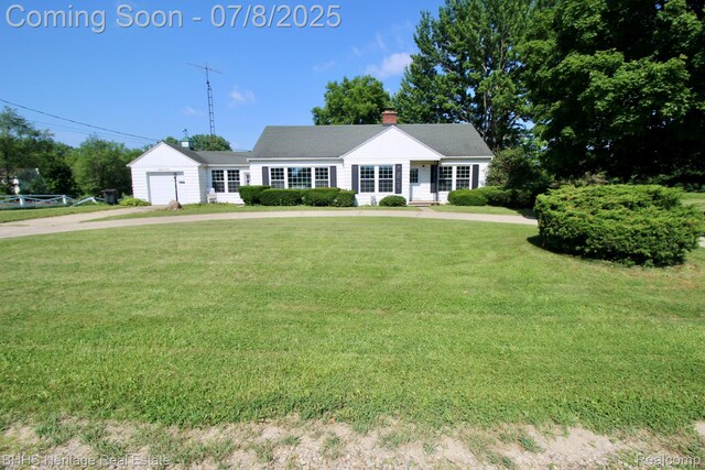 4201 N Burkhart Rd, Howell, MI 48855 - single story home with a front lawn, an attached garage, a chimney, and driveway