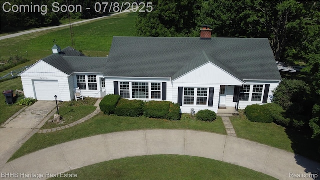 4201 N Burkhart Rd, Howell, MI 48855 - view of front of property featuring a garage, concrete driveway, a chimney, a front lawn, and roof with shingles
