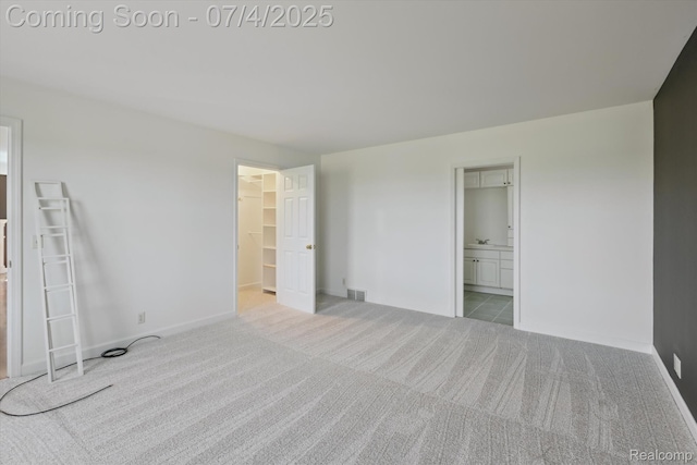 10934 Baker Rd, Frankenmuth, MI 48734 - unfurnished bedroom featuring carpet, a spacious closet, and ensuite bathroom