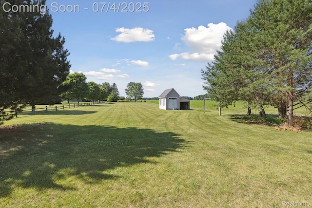 10934 Baker Rd, Frankenmuth, MI 48734 - view of yard featuring a detached garage, an outbuilding, and a view of rural / pastoral area