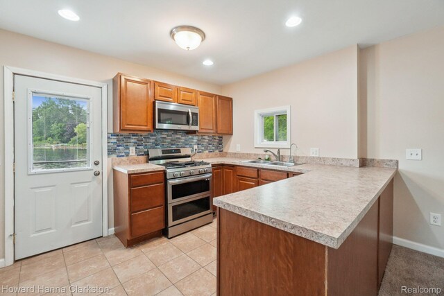 6830 Dixie Hwy, Clarkston, MI 48346 - kitchen featuring stainless steel appliances, a peninsula, light countertops, decorative backsplash, and brown cabinets