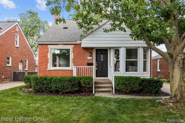 1746 N Lafayette St, Dearborn, MI 48128 - bungalow-style home featuring roof with shingles, a front yard, and brick siding