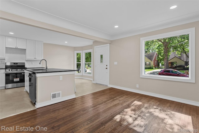 1746 N Lafayette St, Dearborn, MI 48128 - kitchen with stainless steel gas stove, dark countertops, white cabinetry, light wood finished floors, and recessed lighting