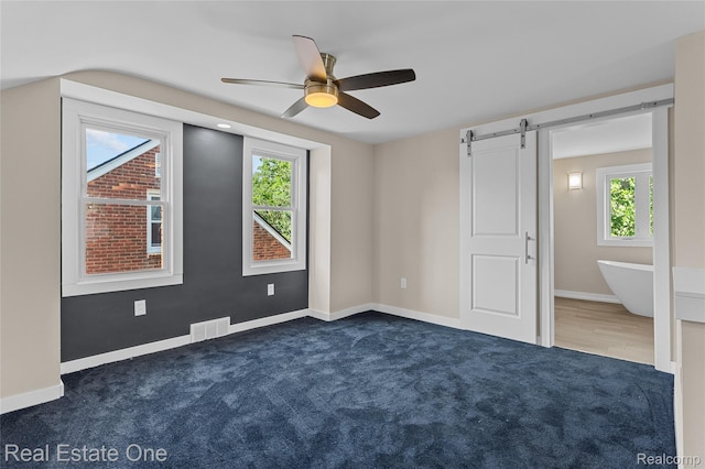 1746 N Lafayette St, Dearborn, MI 48128 - unfurnished bedroom with carpet flooring, a barn door, and ceiling fan