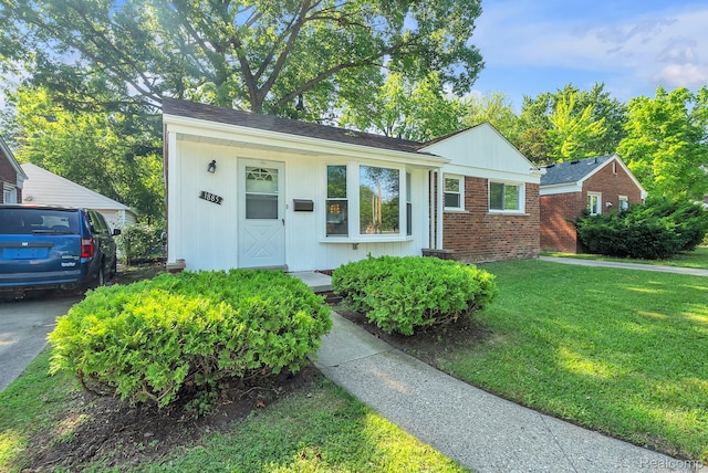 1885 Pelham St, Dearborn, MI 48124 - view of front of home featuring a front lawn, brick siding, and board and batten siding