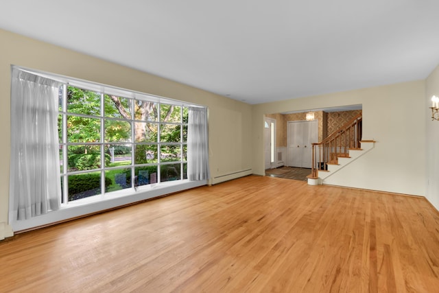 29947 Fernhill Dr, Farmington, MI 48331 - unfurnished living room featuring wood finished floors, baseboard heating, stairway, and a chandelier