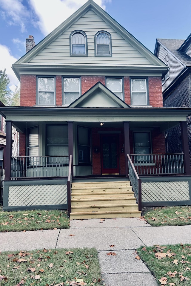 5208 Commonwealth St, Detroit, MI 48208 - traditional style home with brick siding, a porch, and a chimney