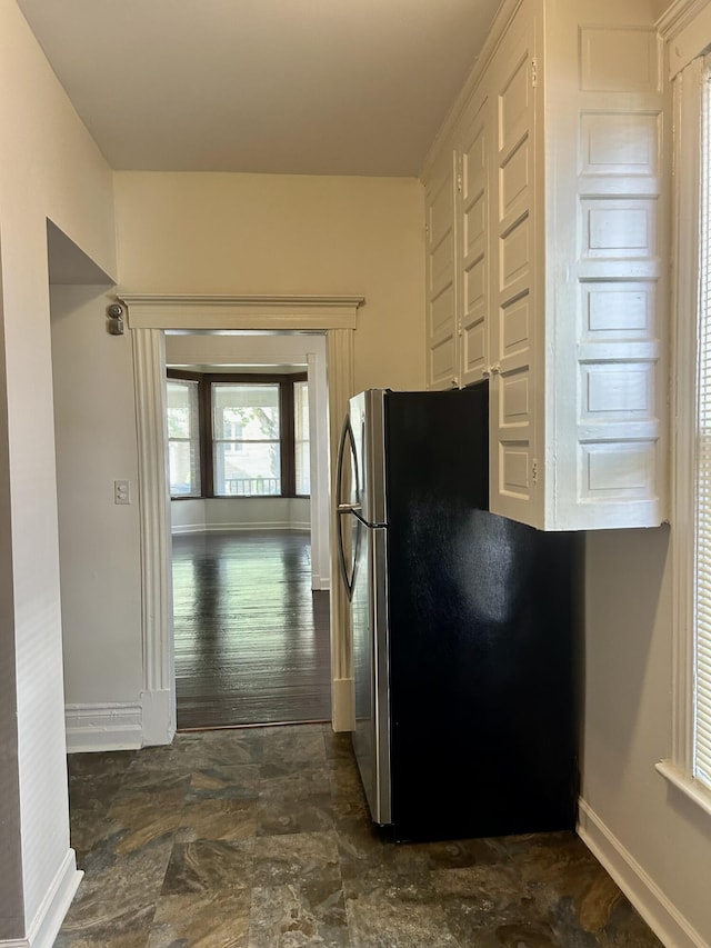 5208 Commonwealth St, Detroit, MI 48208 - kitchen featuring freestanding refrigerator, white cabinets, and dark stone finish floors