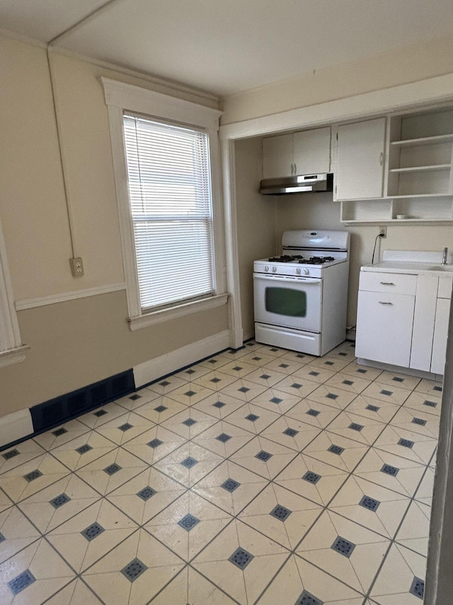 5208 Commonwealth St, Detroit, MI 48208 - kitchen featuring white range with gas cooktop, under cabinet range hood, open shelves, white cabinets, and light countertops