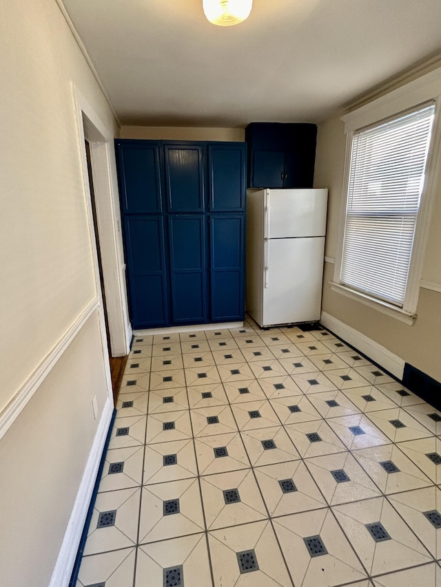 5208 Commonwealth St, Detroit, MI 48208 - kitchen with freestanding refrigerator, blue cabinetry, and light tile patterned floors