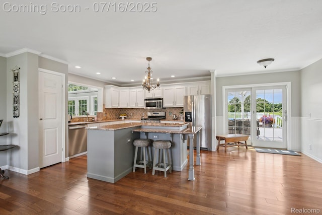 378 Fruitdale Ln, Pinckney, MI 48169 - kitchen featuring stainless steel appliances, a kitchen island, dark wood-style flooring, white cabinetry, and plenty of natural light