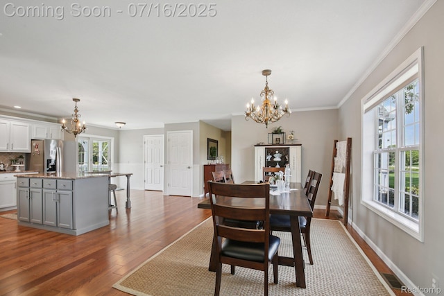 378 Fruitdale Ln, Pinckney, MI 48169 - dining space with a chandelier, wood finished floors, and crown molding