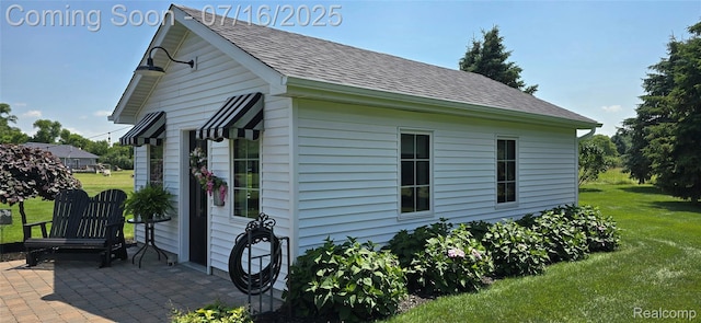378 Fruitdale Ln, Pinckney, MI 48169 - view of property exterior featuring a shingled roof, a patio, and a lawn