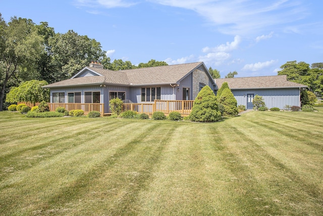 335 Fairway Dr, Coldwater, MI 49036 - view of front of house with a chimney, a front yard, a wooden deck, and a shingled roof