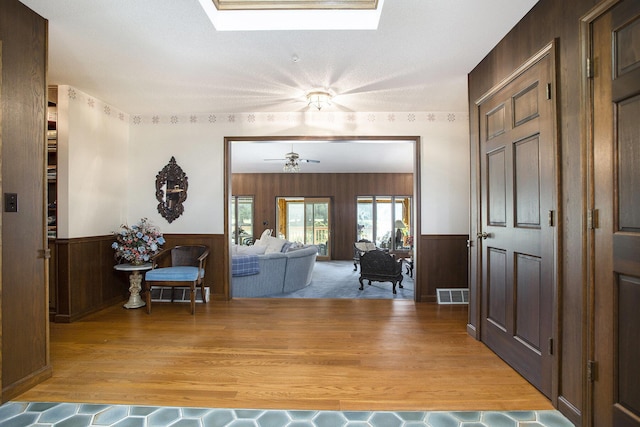 335 Fairway Dr, Coldwater, MI 49036 - foyer featuring a skylight, a wainscoted wall, light wood finished floors, and ceiling fan
