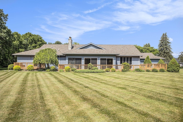 335 Fairway Dr, Coldwater, MI 49036 - back of house featuring board and batten siding, a chimney, a deck, and a lawn