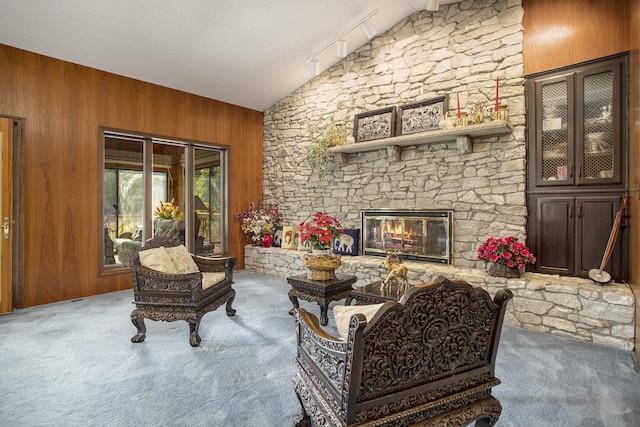 335 Fairway Dr, Coldwater, MI 49036 - living room featuring vaulted ceiling, carpet, wooden walls, a fireplace, and rail lighting