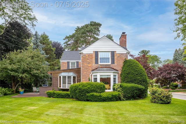 17 Colonial Rd, Grosse Pointe Shores, MI 48236 - traditional-style home featuring a chimney, a front lawn, a deck, and brick siding