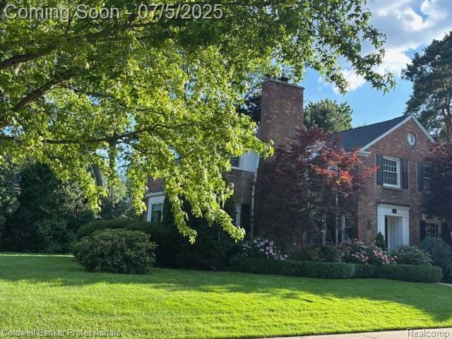 17 Colonial Rd, Grosse Pointe Shores, MI 48236 - view of property exterior featuring a chimney, brick siding, and a lawn