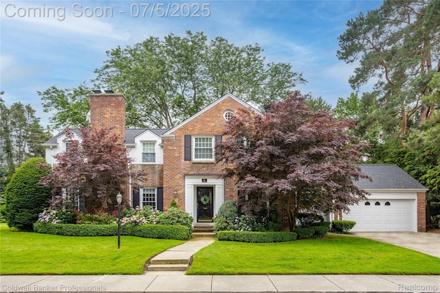 17 Colonial Rd, Grosse Pointe Shores, MI 48236 - view of front of house featuring brick siding, a front yard, a chimney, and driveway