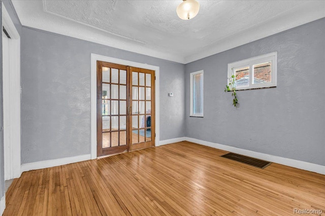 18040 Indiana St, Detroit, MI 48221 - empty room featuring hardwood / wood-style flooring, a textured ceiling, and a textured wall