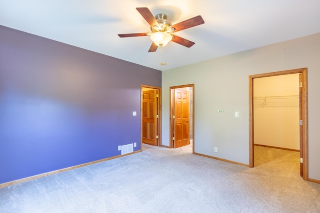 56234 Sink Rd, Dowagiac, MI 49047 - unfurnished bedroom with light carpet, a walk in closet, a closet, and ceiling fan