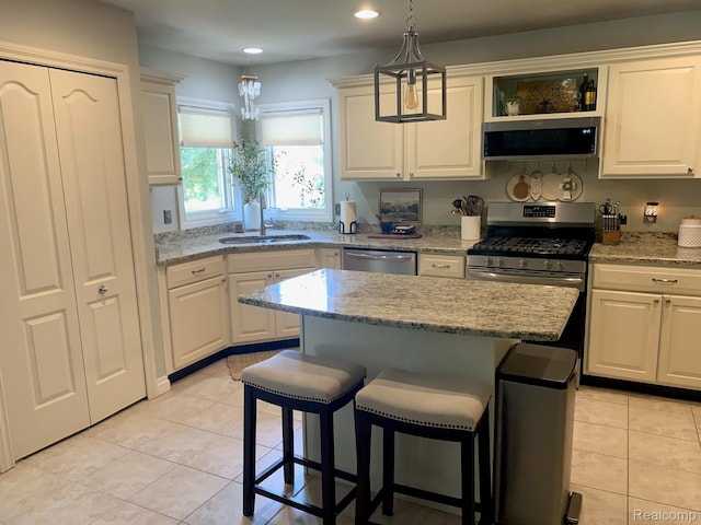 23287 Angel Park Dr, Macomb, MI 48042 - kitchen with appliances with stainless steel finishes, light tile patterned floors, a center island, a breakfast bar area, and recessed lighting